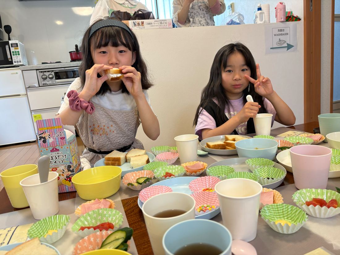 テーブルを囲んでサンドイッチを食べる子どもたち